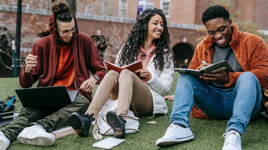 College students on campus at an American university, sitting together outside.